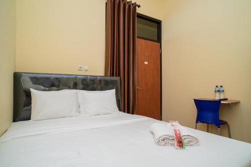RedDoorz Syariah near Jembatan Merah Plaza tesisinde bir odada yatak veya yataklar