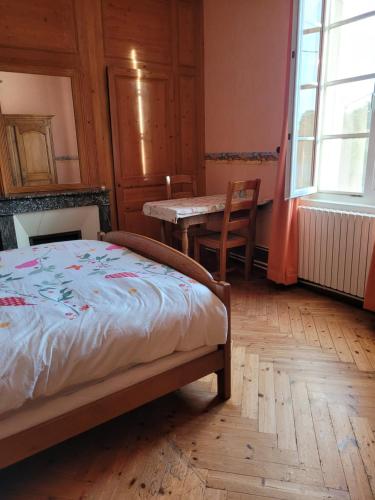 um quarto com uma cama, uma mesa e uma janela em Chambre chez l'habitant 3 em Biville-la-Baignarde