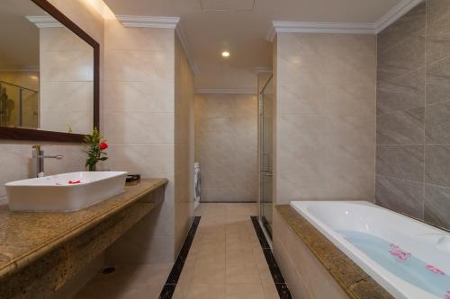 a bathroom with a tub and a sink at Hanoi Calista Hotel & Spa in Hanoi