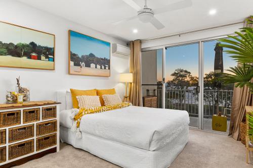 a bedroom with a white bed and a large window at 3 Bedroom Penthouse - Short Walk to Sandstone Point in Bongaree