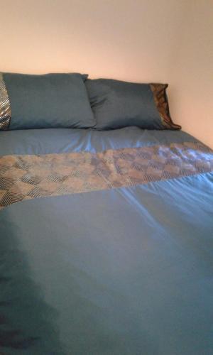 a bed with blue sheets and pillows on it at Quin homes in Birmingham