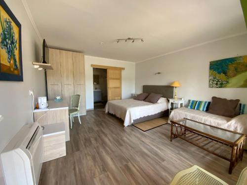 une chambre d'hôtel avec deux lits et un canapé dans l'établissement L´oliveraie, à Perpignan