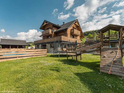 a large wooden house with a green lawn in front of it at Apartament Nurt Food Uroczysko Jaworki in Jaworki