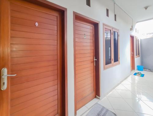 een houten deur in een kamer met een gang bij KoolKost At Jalan Ciheulang Bandung - Minimum Stay 30 Night in Bandung