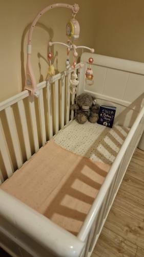 a crib with a book and stuffed animals on it at Quin homes in Birmingham
