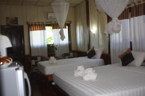 a room with two beds with white towels on them at Sengahloune Resort in Ban Khon