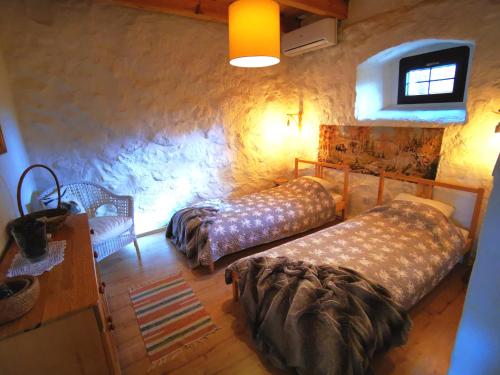 a bedroom with two beds and a table and a chair at Zabytkowy dom z 2 sypialniami i 2 ogródkami in Wydminy
