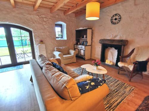 a living room with a couch and a fireplace at Mazurska Sielanka - klimatyczny apartament, 2 sypialnie i 2 ogródki in Wydminy