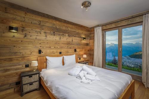 um quarto com uma cama grande e uma janela grande em Chalet Micheline em Riddes