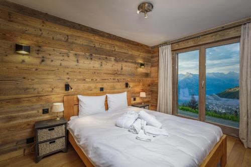 a bedroom with a large bed with a large window at Chalet Micheline in Riddes