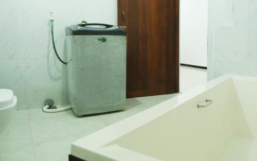 a bathroom with a toilet and a small refrigerator at Cottage 23 in Kurunegala