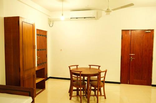 a dining room with a table and chairs and a cabinet at Cottage 23 in Kurunegala