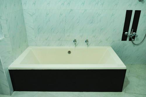 a white bath tub in a bathroom with a mirror at Cottage 23 in Kurunegala
