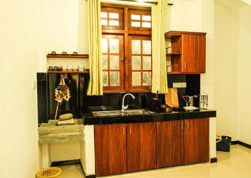 cocina con fregadero y ventana en Cottage 23, en Kurunegala