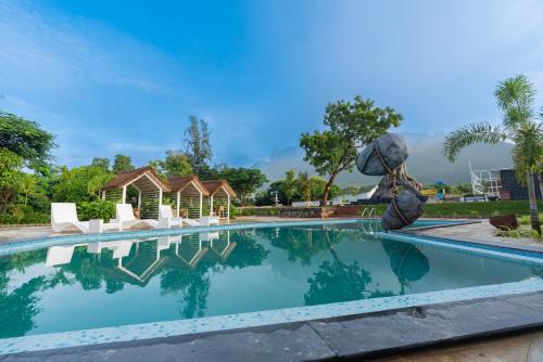 a pool at the resort with chairs and a fountain at DARZA LUXURY RESORTs in Coimbatore
