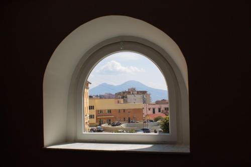 an arch window with a view of a city at Palazzo Cappuccini Art Relais in Naples