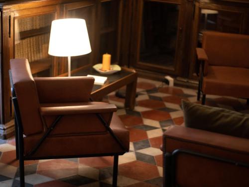 a living room with a chair and a table with a lamp at Palazzo Cappuccini Art Relais in Naples