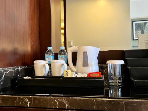 a tray with a coffee maker and cups on a counter at Holiday Inn & Suites Makati by IHG in Manila
