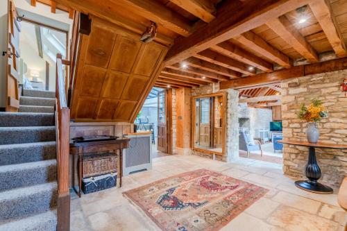 a living room with a staircase and a fireplace at Barns Lee in Malmesbury
