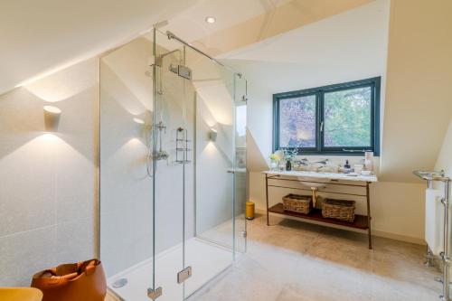 a bathroom with a glass shower and a sink at Barns Lee in Malmesbury