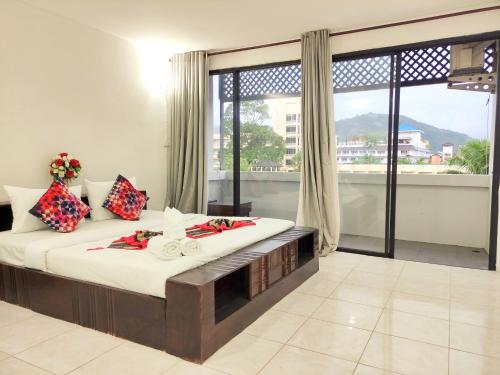 a bedroom with a bed and a large window at Sea Beach Paradise in Patong Beach