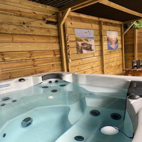 una bañera de hidromasaje en una cabaña con paredes de madera en Bed and Breakfast Heerenveen Centrum met Privé Sauna en Jacuzzi, en Heerenveen