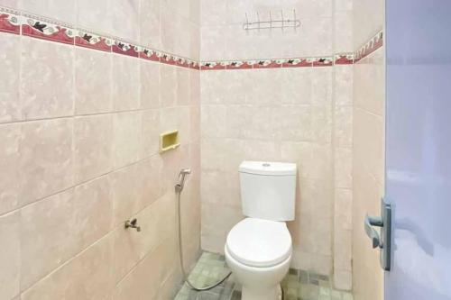 a bathroom with a white toilet in a room at KoolKost Syariah near Stasiun Tanjung Karang Lampung in Bandar Lampung