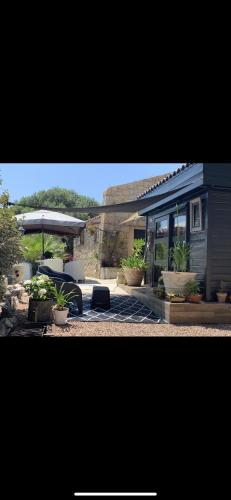a tiny house with a table and an umbrella at Residence Paradisu Ajaccio in Appietto