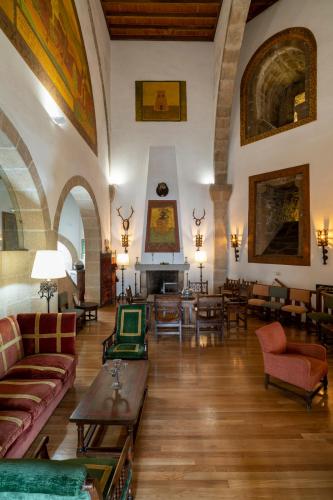a living room with couches and tables and a fireplace at Parador de Vilalba in Villalba