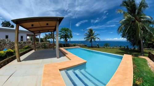 a swimming pool in a villa with the ocean in the background at The Gabayan Riviera in Siquijor