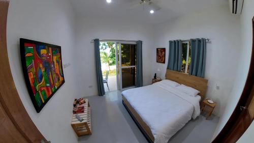 een slaapkamer met een bed en een schilderij aan de muur bij The Gabayan Riviera in Siquijor