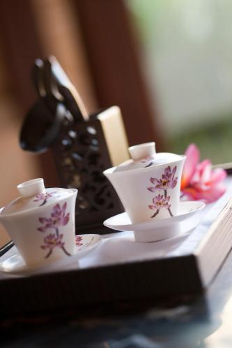 a table with two tea cups and a purse at Wanda Reign Resort & Villas Sanya Haitang Bay in Sanya