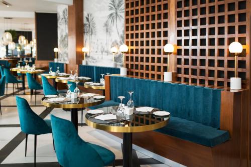 a dining room with blue chairs and tables at Le Centell Hotel & Spa in Antananarivo