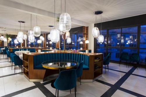 a restaurant with blue chairs and tables and chandeliers at Le Centell Hotel & Spa in Antananarivo