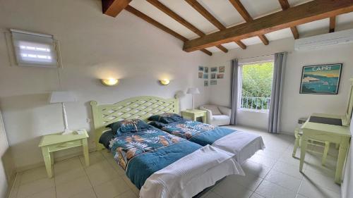 サント・マキシムにあるMazets du Soleilのベッドルーム1室(ベッド1台、テーブル2台、窓付)