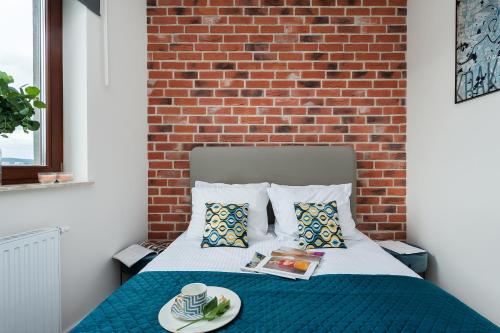 a bedroom with a bed with a brick wall at Avenue Apartment by LoftAffair in Kraków