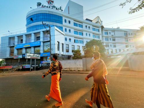 two women walking down the street in front of a building at Green Park Residency in Kannur