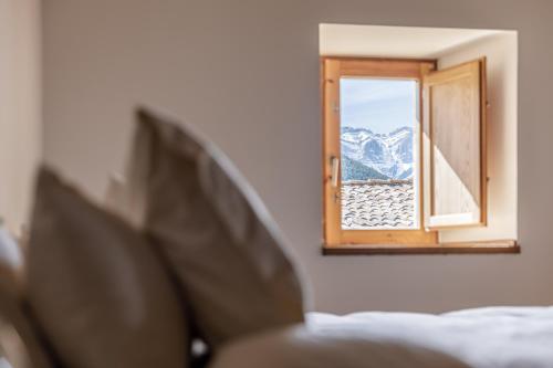 a bedroom with a window with a view of a mountain at Cal Calsot Casa Rural "Adults Only" in Montellá