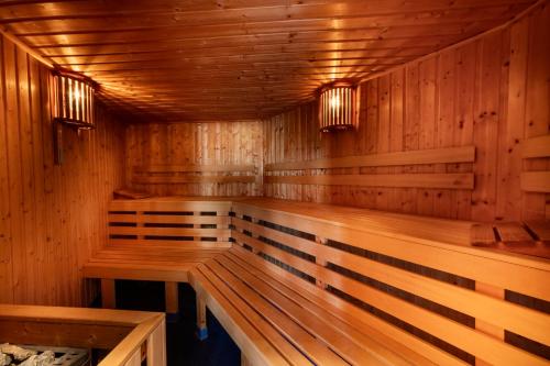 a wooden sauna with two benches in it at Hotel Forstmeister in Schönheide