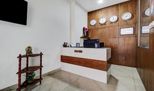 a lobby with a counter with clocks on the wall at Treebo Purple Orchid Boutique in Bengaluru
