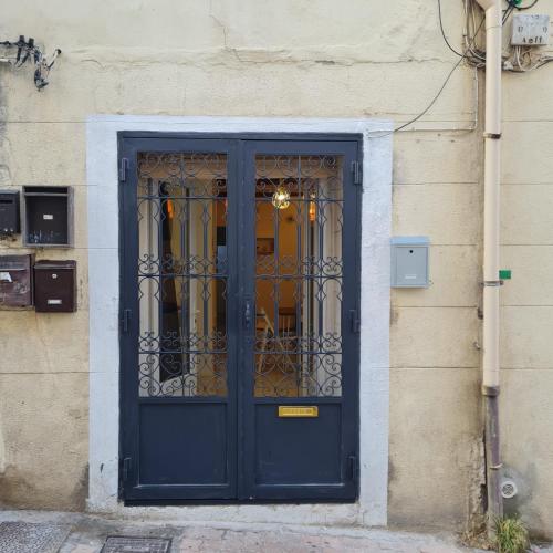 una porta blu con un cancello di metallo su un edificio di Sète, T2 cosy et atypique, Jardin Château d'eau, centre ville a Sète