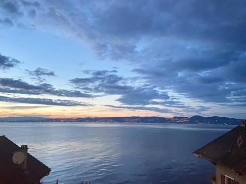 a view of a large body of water at sunset at BORD DE LAC,2 chambres SUPERBE VUE LAC 5mn Evian in Lugrin