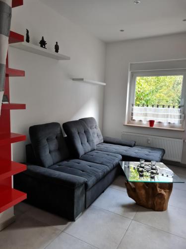 a living room with a blue couch and a table at Ferienwohnung am Kurpark in Bad Rothenfelde