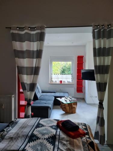 a living room with a bed and a couch at Ferienwohnung am Kurpark in Bad Rothenfelde