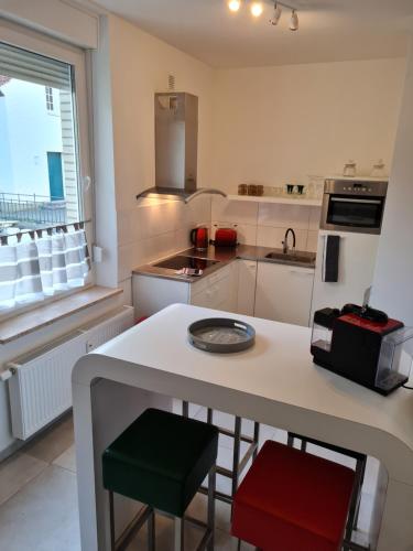 a kitchen with a white counter with two stools at Ferienwohnung am Kurpark in Bad Rothenfelde