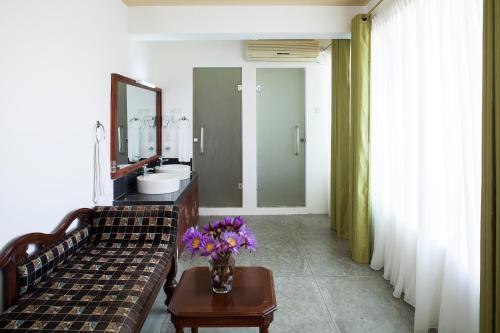 a bathroom with a couch and a sink and a mirror at The Albatross, Kandy in Digana