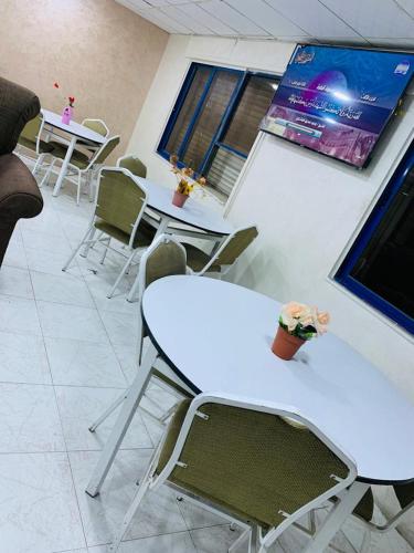 a room with white tables and chairs and windows at Asia Hotel in Amman