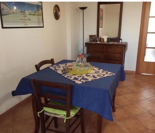 einen Esstisch mit einem blauen Tischtuch und Stühlen in der Unterkunft Bounganville 127 in Alcamo Marina