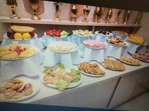 uma mesa cheia de diferentes tipos de alimentos em pratos em Boutique hotel Shakh em Bucara