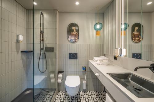 ein Bad mit einer Dusche, einem WC und einem Waschbecken in der Unterkunft BOUTIQUE Hotel by Continental Park in Luzern